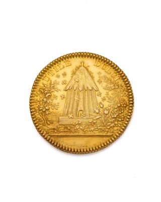 gros plan d'une pièce d'or sur une surface blanche
