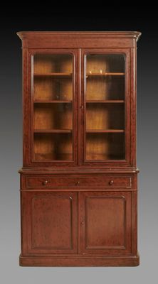 an antique mahogany bookcase with glass doors