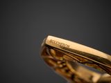 a close up of a gold ring on a black surface