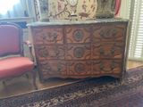 a dresser with a marble top and a chair in front of it