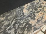 a table with a marble top on a tile floor