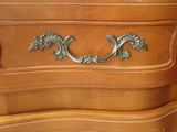 a close up of a wooden dresser with a metal handle