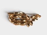 an image of a gold brooch with leaves on it
