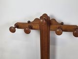a wooden coat rack with a metal tray underneath it