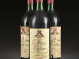 three bottles of red wine sitting on top of a table
