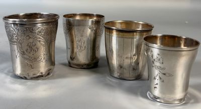 quatre tasses en argent posées les unes à côté des autres sur une table