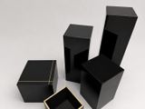 three black boxes with gold trims on a white background