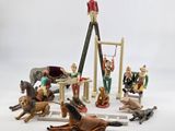 toy figurines of a man on a ladder with horses and dogs