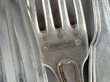 three forks and a knife on a table