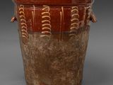 brown and brown vase with handles on a gray surface