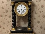 a black and gold clock sitting on top of a table