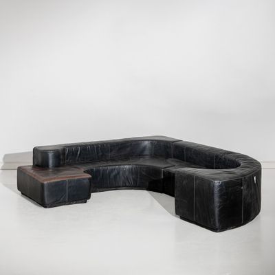 une photo d'un canapé modulable en cuir noir avec une table basse