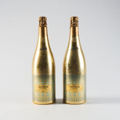 deux bouteilles de champagne posées l'une à côté de l'autre sur une surface blanche