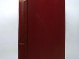 a red book sitting on top of a table next to a white wall