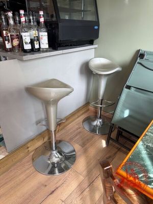 deux tabourets dans un coin d'une pièce où une télévision est accrochée au mur