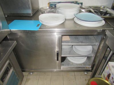 une cuisine où il y a beaucoup d'assiettes et de bols sur le plan de travail