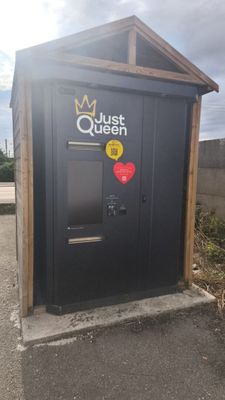 a black outhouse with a red heart sticker on it