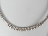 a silver necklace and a pair of earrings on a table
