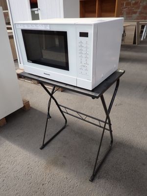 un micro-ondes blanc posé sur une table pliante