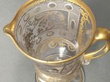 a glass cup with a gold decoration on it