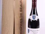 a bottle of red wine in front of a wooden box