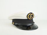 black and white hat with gold emblem on top of it