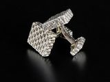 a close up of a pair of silver cufflinks on a black surface