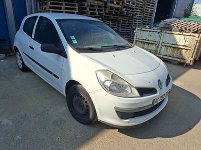une photo d'une petite voiture blanche garée devant un immeuble