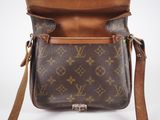 a close up of a louis vuitton cross body bag on a white background