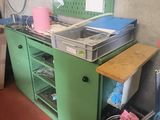 a green kitchen with a sink and a green cabinet