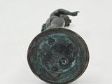 a bronze statue of a boy laying on the ground