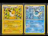 Quatre cartes Pokémon sont alignées les unes à côté des autres sur une surface noire.