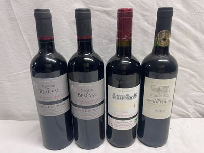four bottles of wine are lined up on a table