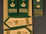 three green and gold military uniforms are on display on a table
