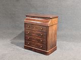 une petite commode en bois sur fond gris