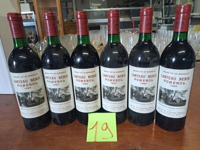 six bouteilles de vin rouge alignées sur une table, avec une étiquette de prix