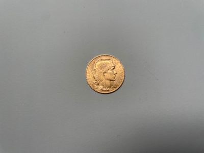 gros plan d'une pièce d'or sur une surface grise