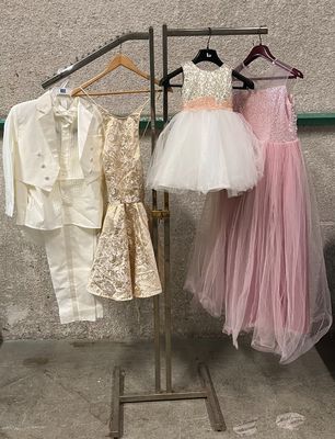 three dresses hanging on a clothes rack in a room
