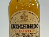 une bouteille de whisky posée sur une surface blanche