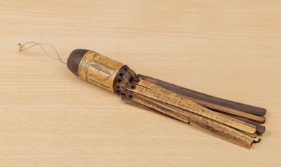 un bâton en bois muni d'un long manche, posé sur une table