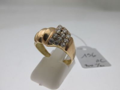 une image d'une bague en or avec des diamants sur une surface blanche