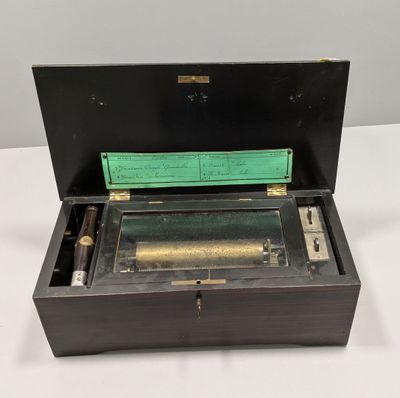 an old fashioned musical box sitting on top of a white table