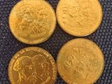 three different types of gold coins sitting on top of a blue cloth