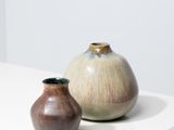deux vases posés sur une table blanche, sur fond blanc