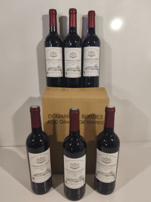 six bottles of red wine sit in front of a cardboard box
