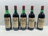 four bottles of wine are lined up on a table