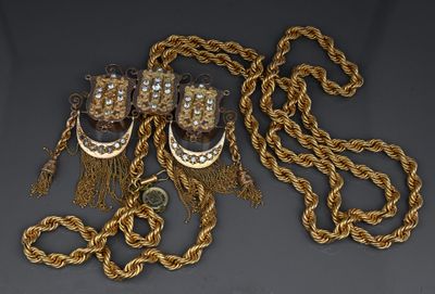 a close up of a gold chain with a pair of shoes on it