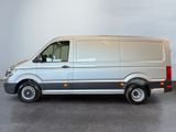 the silver van is parked in a room with a gray wall