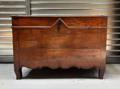 a wooden chest sitting on the floor in front of a garage door