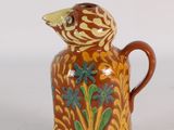a brown and yellow vase with a bird on it